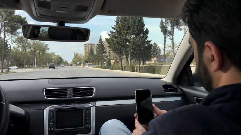 Traveller using mobile internet during a Ganja Airport city transfer