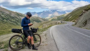 Touring cyclist checking smartphone navigation beside a Georgian road