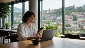 Remote worker using a laptop and smartphone in a Tbilisi coworking café