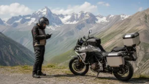 Motorcycle traveller checking a smartphone at a Georgian mountain viewpoint