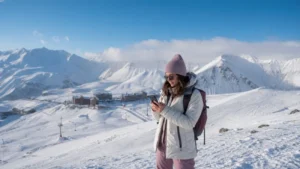 Winter traveller checking a smartphone at Gudauri mountain resort
