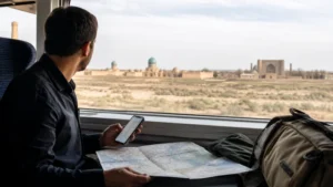 Traveller planning Uzbekistan data use during a train journey.