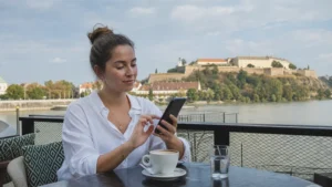 Traveller setting up a smartphone at a Danube-side cafe in Novi Sad.