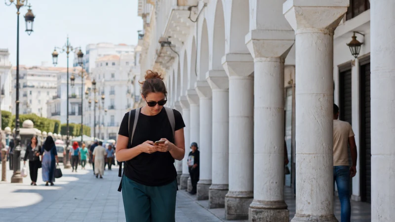 Traveller using mobile internet while travelling in Algeria