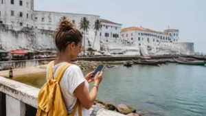 Traveller using a smartphone on the seafront in Cape Coast
