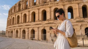 Traveller using a smartphone for Internet El Jem Amphitheatre in Tunisia