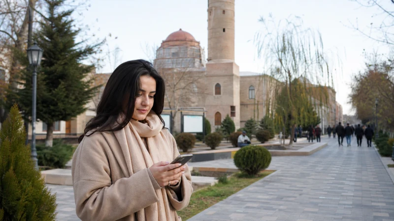 Visitor checking mobile data while sightseeing in Ganja