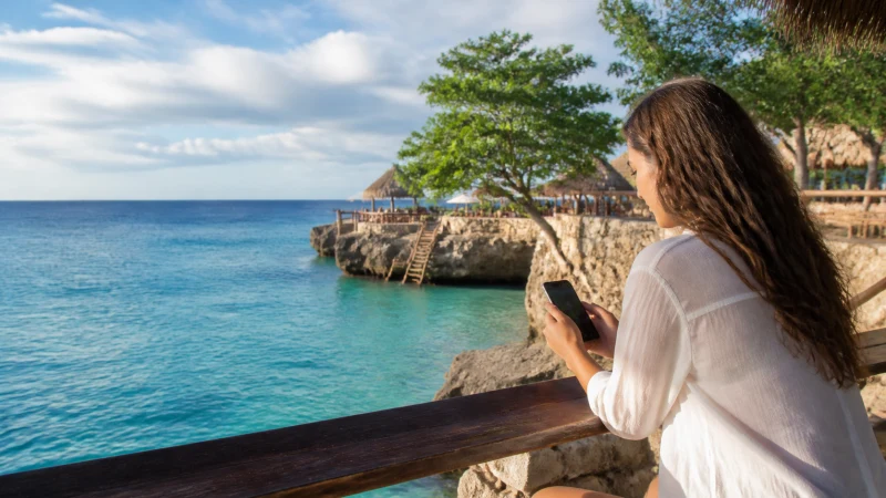 Traveller using a smartphone in Jamaica while staying connected in Negril