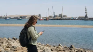 Traveller using a smartphone in Namibia while staying connected in Walvis Bay
