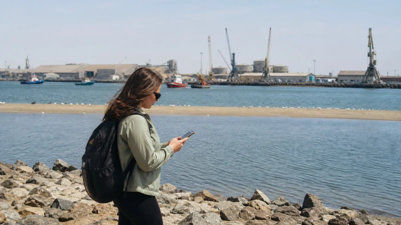 Traveller using a smartphone in Namibia while staying connected in Walvis Bay