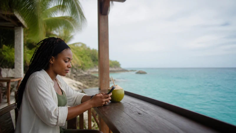 Traveller using a smartphone in Jamaica while staying connected on a solo trip to Jamaica