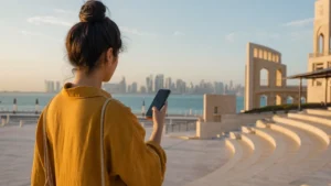 Traveller using a smartphone in visitor using a phone near Katara cultural architecture