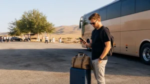 Traveller using a smartphone at a public coach stop on the Uzbekistan route.
