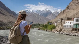 Traveller using a smartphone for mobile internet in khorugh: esim and pamir travel guide