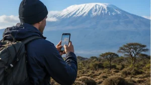 Traveller using mobile internet near Mount Kilimanjaro