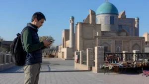 Traveller using a smartphone for mobile internet in kulob: esim and travel data guide