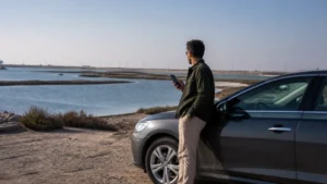 Traveller using a smartphone in a Kuwait setting related to mobile data on the road from kuwait city to al khiran