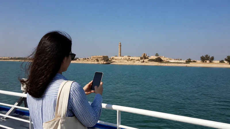 Traveller using a smartphone in a Kuwait setting related to internet access on the journey to failaka island