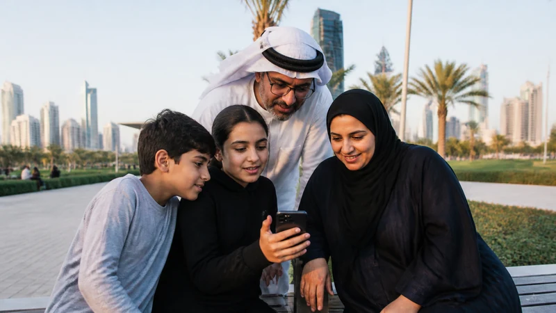 Traveller using a smartphone in a Kuwait setting related to keeping the family connected on a trip to kuwait