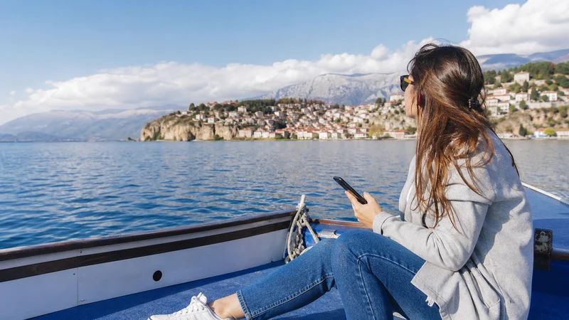 Traveller using a smartphone during lake ohrid in North Macedonia.