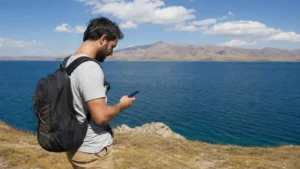Traveller using a smartphone while using mobile internet around Lake Sevan