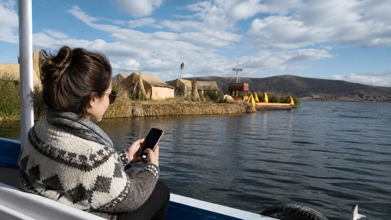 Traveller using a smartphone in Peru for lake titicaca mobile internet