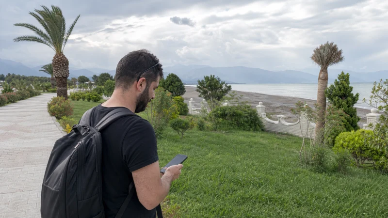 Traveller using mobile data on a green Lankaran route