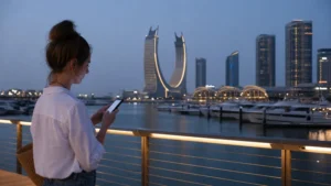 Traveller using a smartphone in traveller using a phone on Lusail Marina promenade