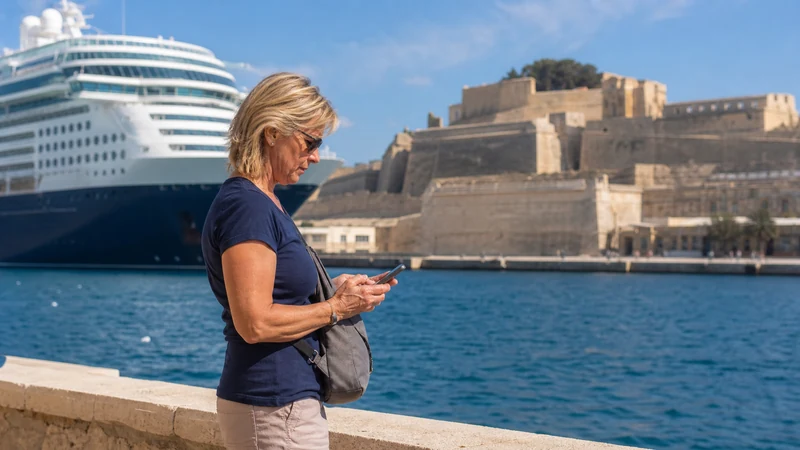 Cruise traveller using a smartphone near Valletta’s port