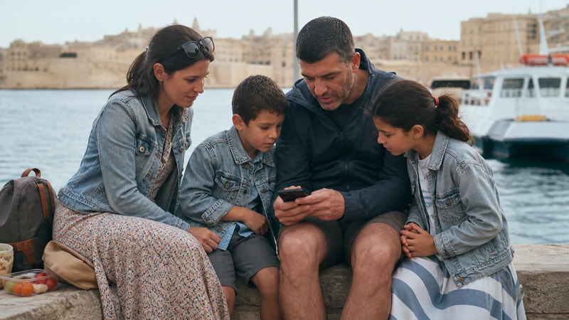 Traveller using a smartphone in Malta while sharing mobile data on a Malta family trip