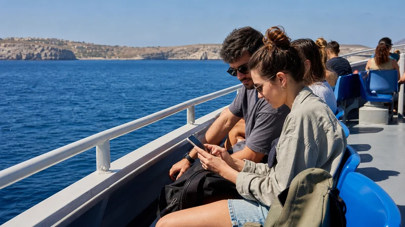 Traveller using a smartphone in Malta while staying connected while island-hopping in Malta