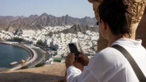 Traveller using a smartphone during network settings at a Muscat viewpoint