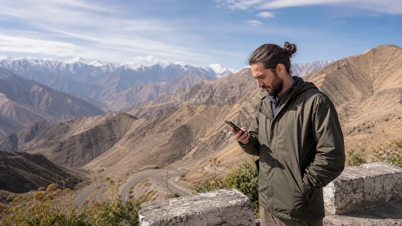 Traveller checking network selection at a Tajik mountain pass