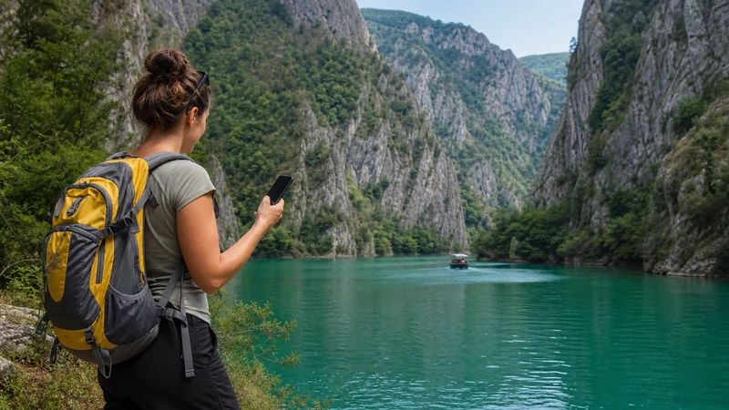 Traveller using a smartphone during mobile internet at matka canyon in North Macedonia.