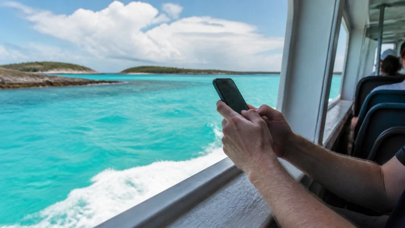 Traveller checking mobile data during a ferry journey in The Bahamas