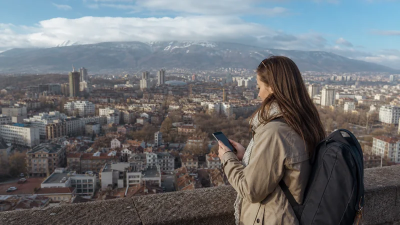 Traveller checking mobile data while overlooking Sofia