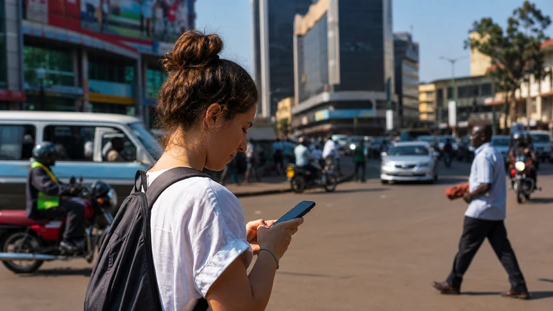 Traveller using mobile data in central Kampala.