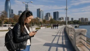 Traveller using a smartphone on Baku's Caspian promenade