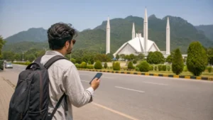 Traveller using mobile navigation near Faisal Mosque in Islamabad