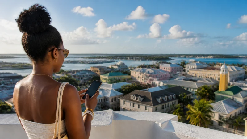 Traveller using a smartphone above Nassau and its harbour