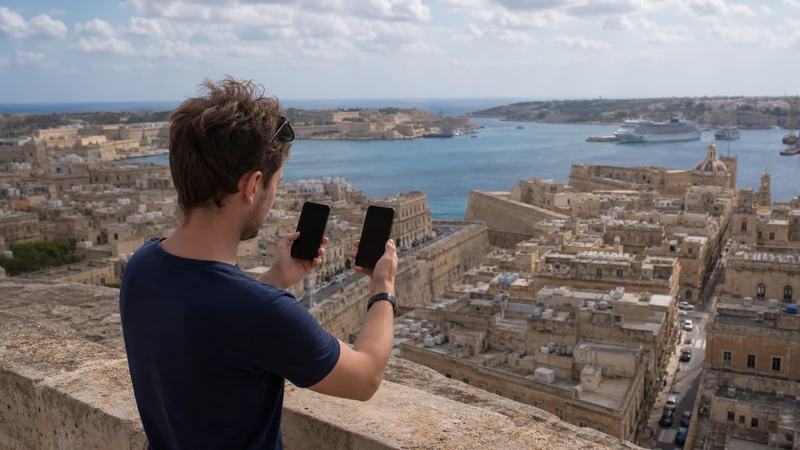 Traveller using a smartphone in Malta while comparing mobile networks in Malta