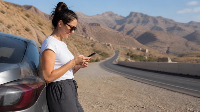 Traveller using a smartphone during traveller on Muscat–Nizwa route