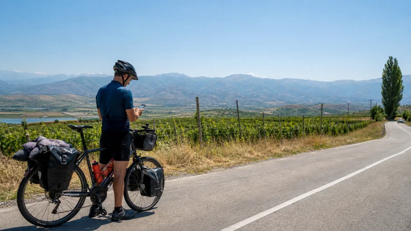 Traveller using a smartphone during cycling in north macedonia in North Macedonia.