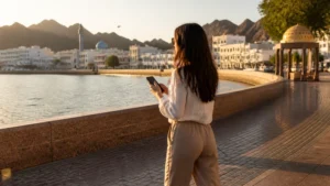 Traveller using a smartphone during iPhone user on Muttrah Corniche