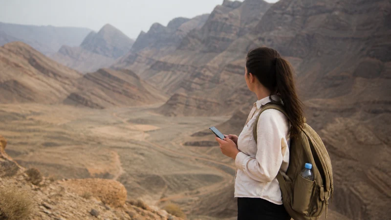 Traveller using a smartphone during prepared traveller in remote Oman