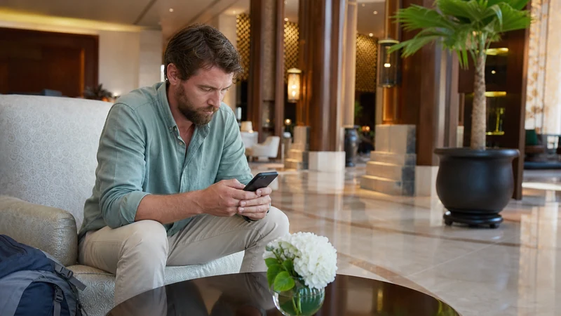 Traveller using a smartphone during traveller planning near Oman–Yemen border far from checkpoint