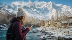 Traveller using mobile data in snowy Hunza Valley