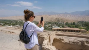 Traveller using a smartphone for mobile internet in panjakent: esim, wi-fi and travel tips