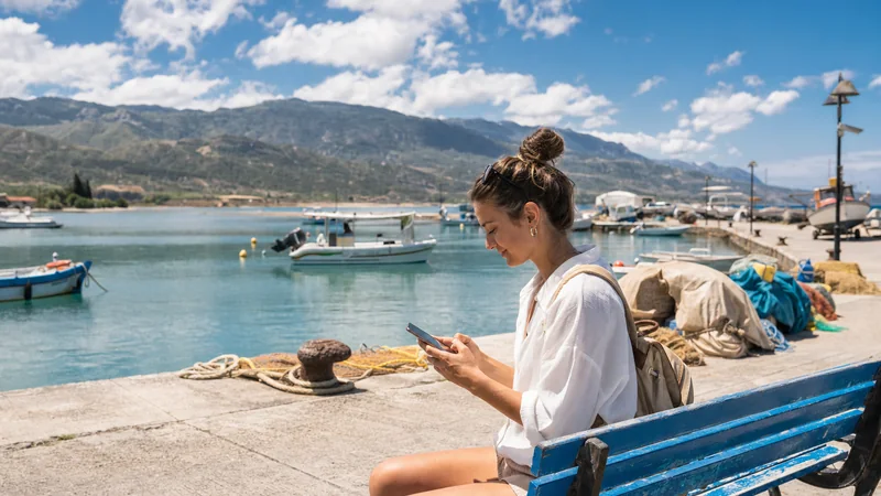 Traveller checking a smartphone beside Latchi harbour
