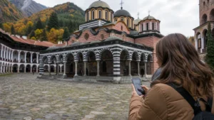 Traveller checking a smartphone outside Rila Monastery